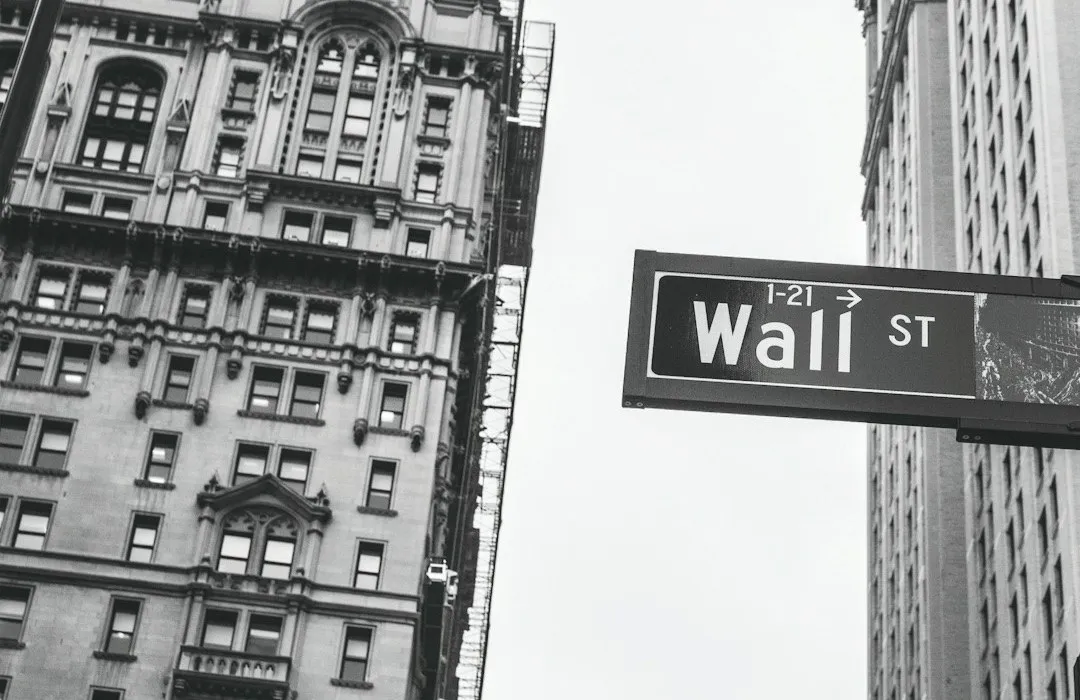 The Wall Street sign between Manhattan towers